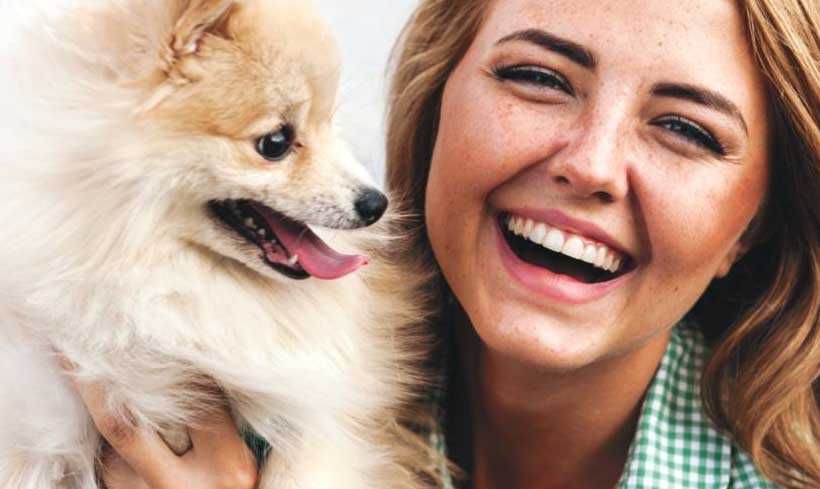 Image of a dog and smiling pet owner